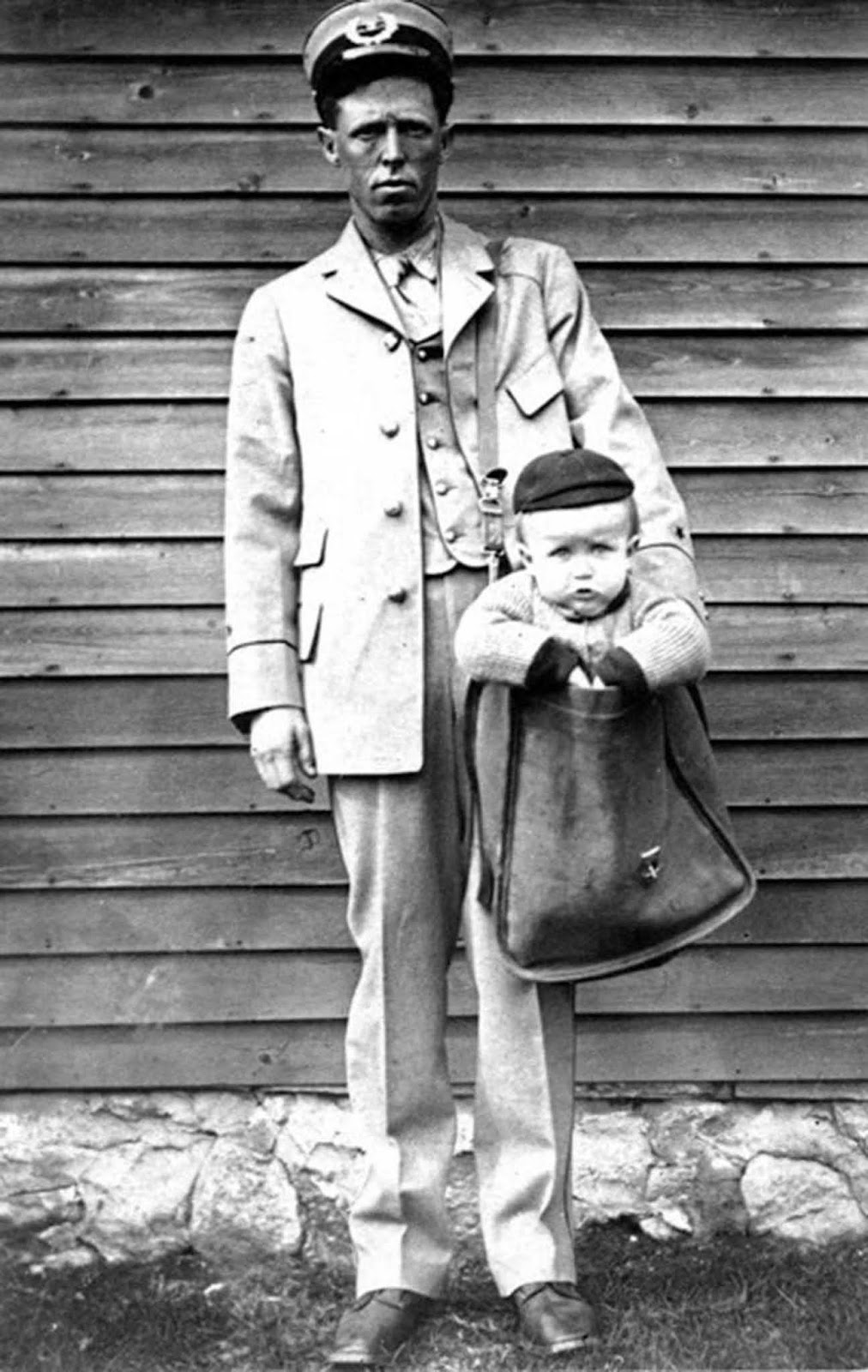 A mailman with a baby (most likely a stage photograph).